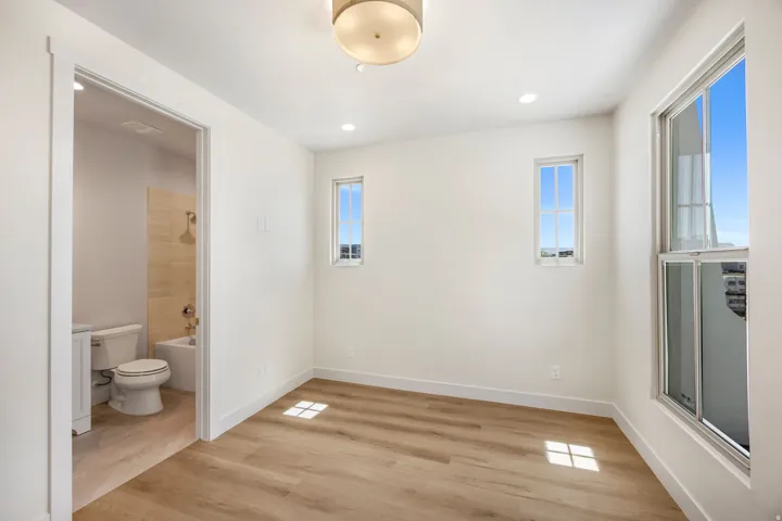Wood-finish flooring throughout, bright white walls, and a recessed lighting package