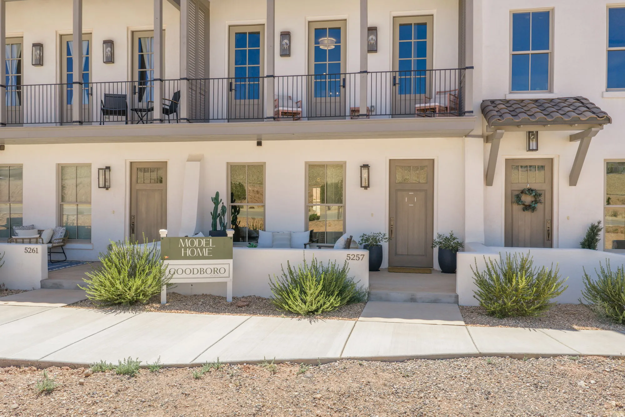 White stucco exterior with multiple balconies featuring black wrought iron railings