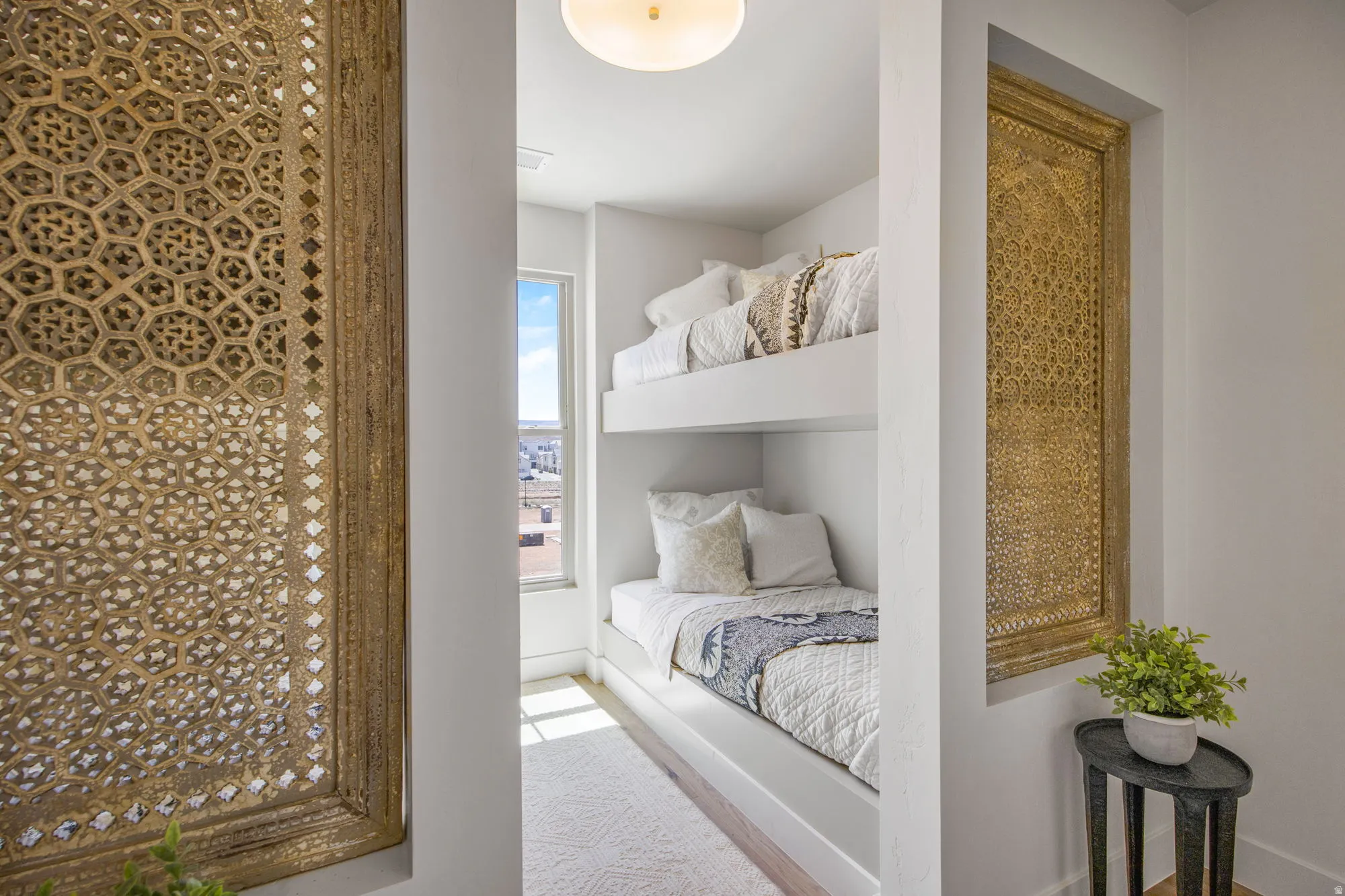 Built-in bunk beds with recessed lighting, complemented by a window with natural light
