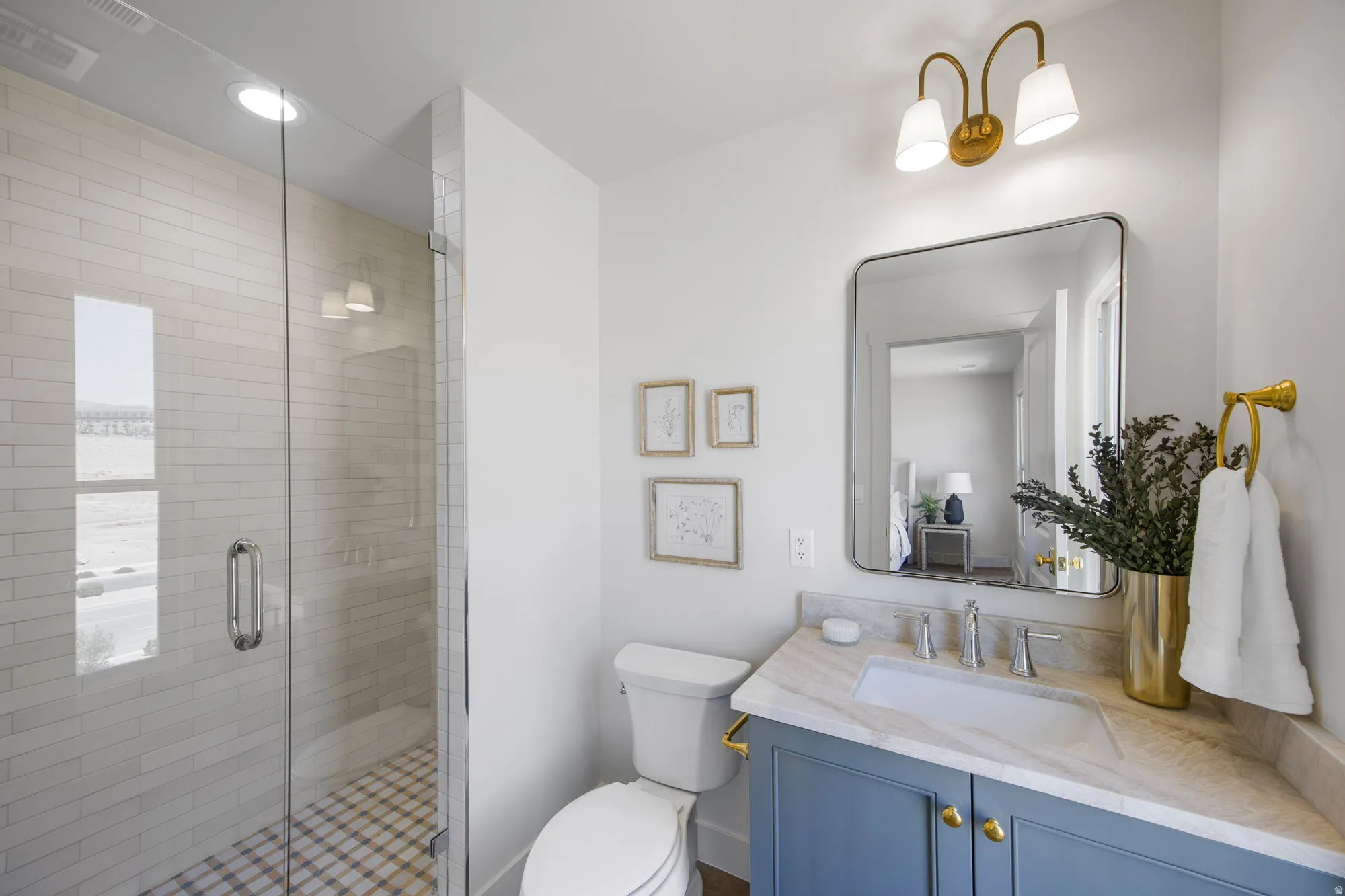Walk-in shower with clear glass enclosure and white subway tile surround
