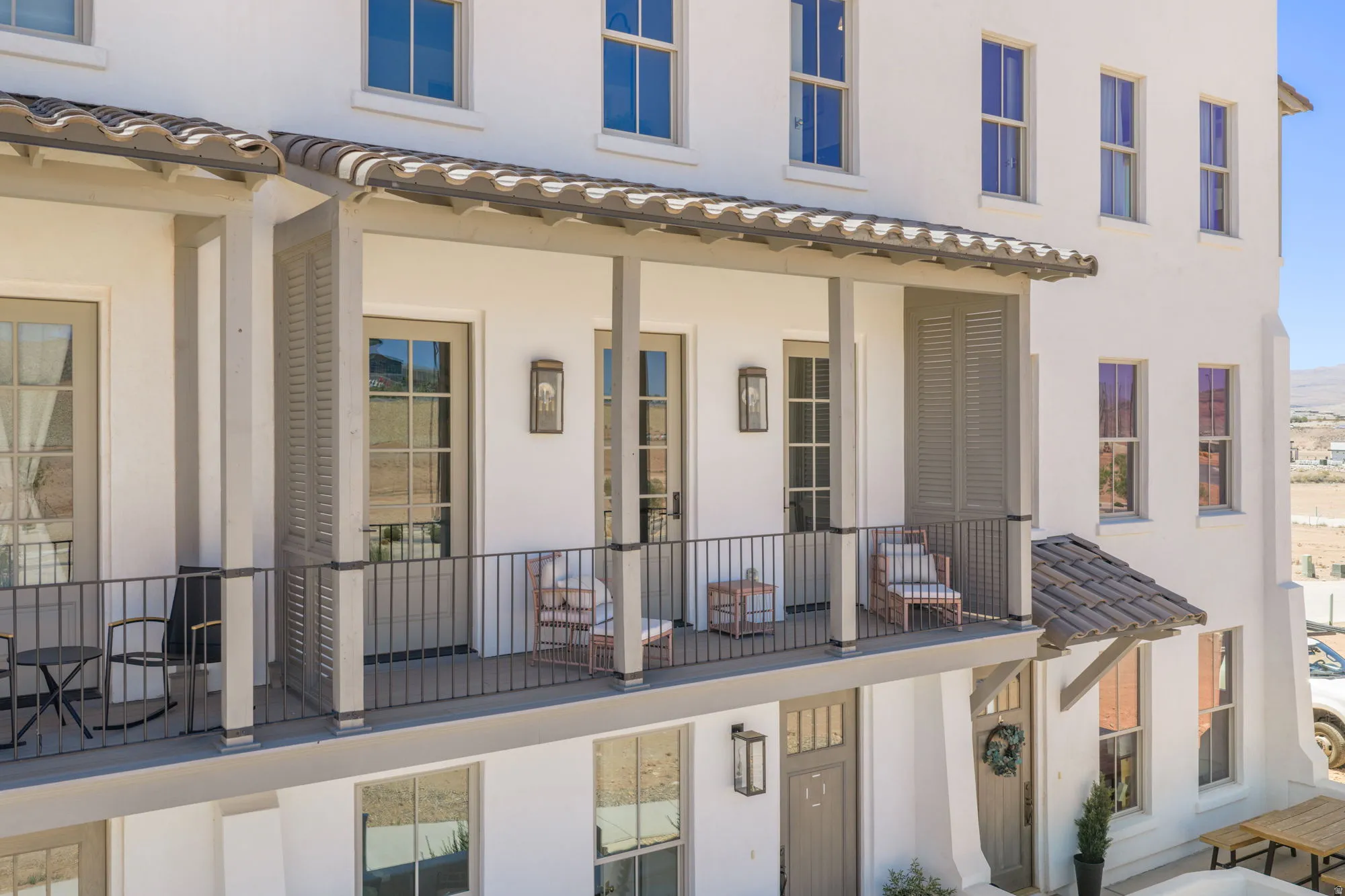 Upper-level balcony featuring a tile roof, recessed lighting, and a dark metal railing