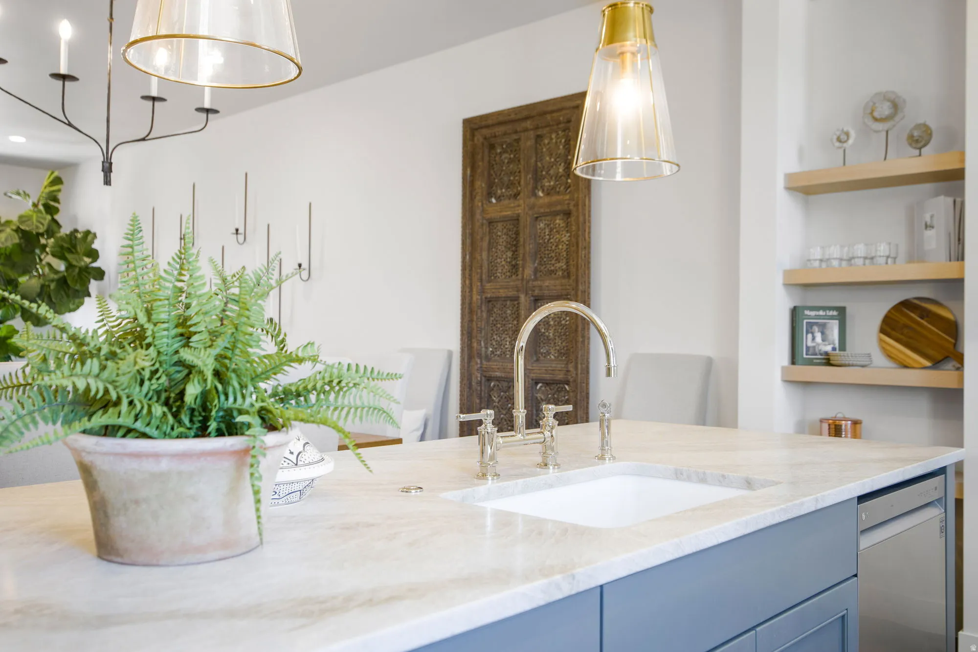Large island with a built-in sink, light-colored countertop, and blue cabinetry