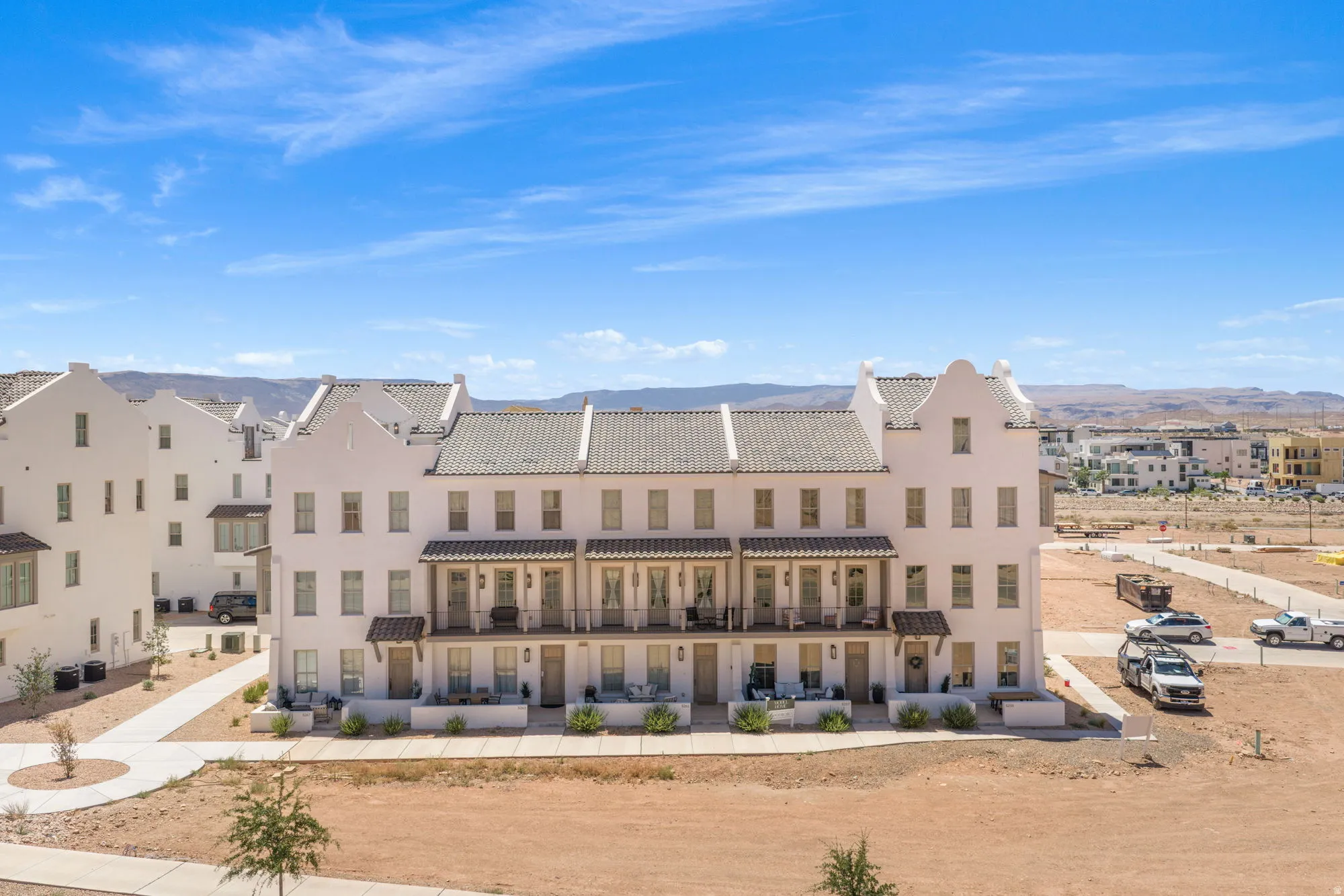 White stucco exterior with multiple gables and a gray tile roof