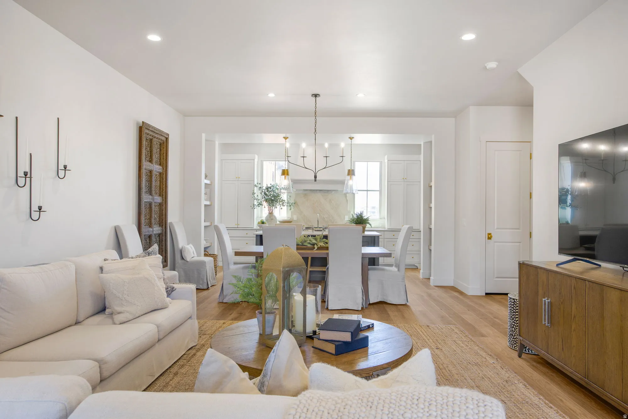 Open-concept living space with light-tone wood flooring and recessed lighting
