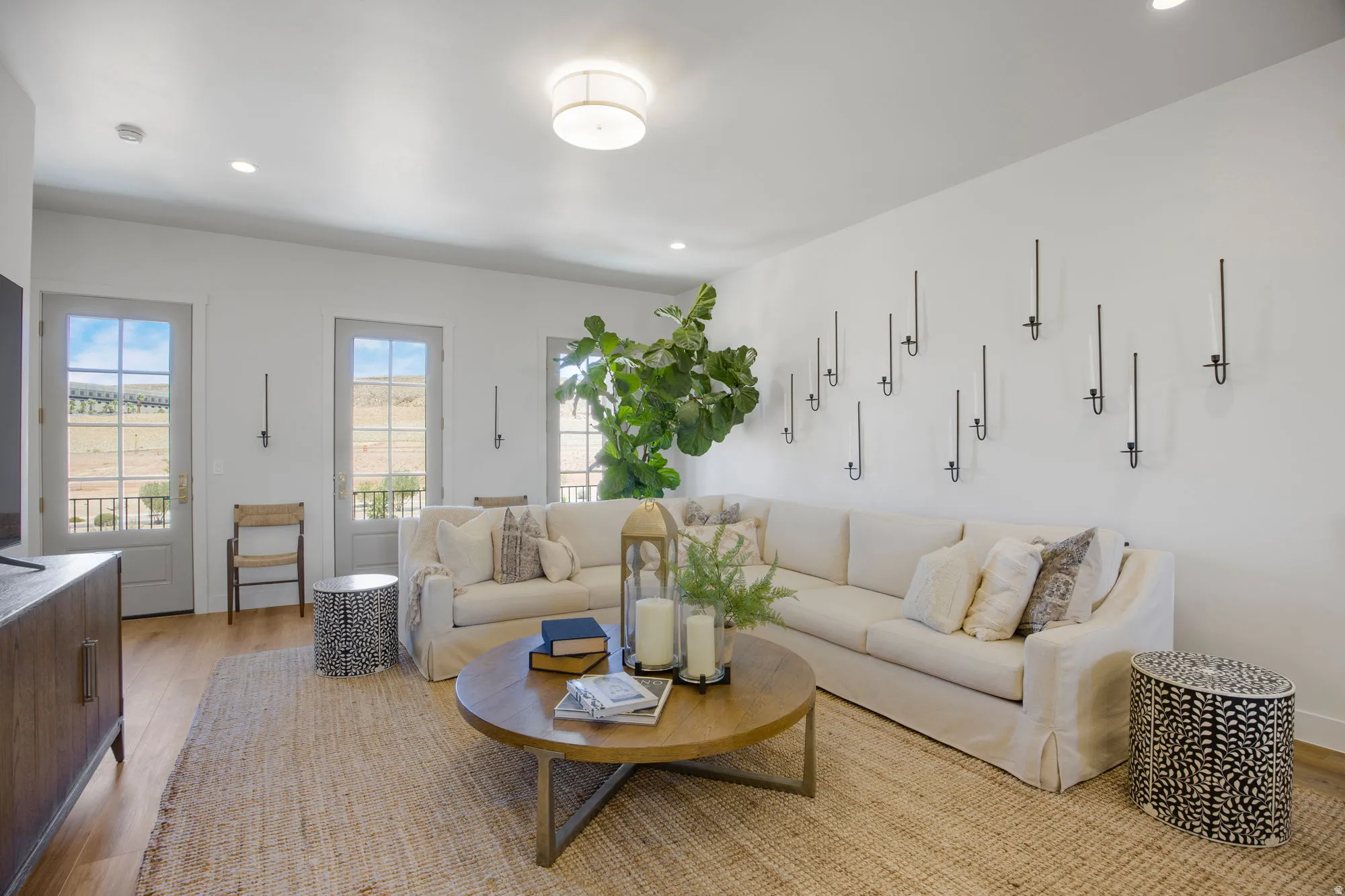Recessed lighting, wood-finish flooring, and multiple French doors with transoms