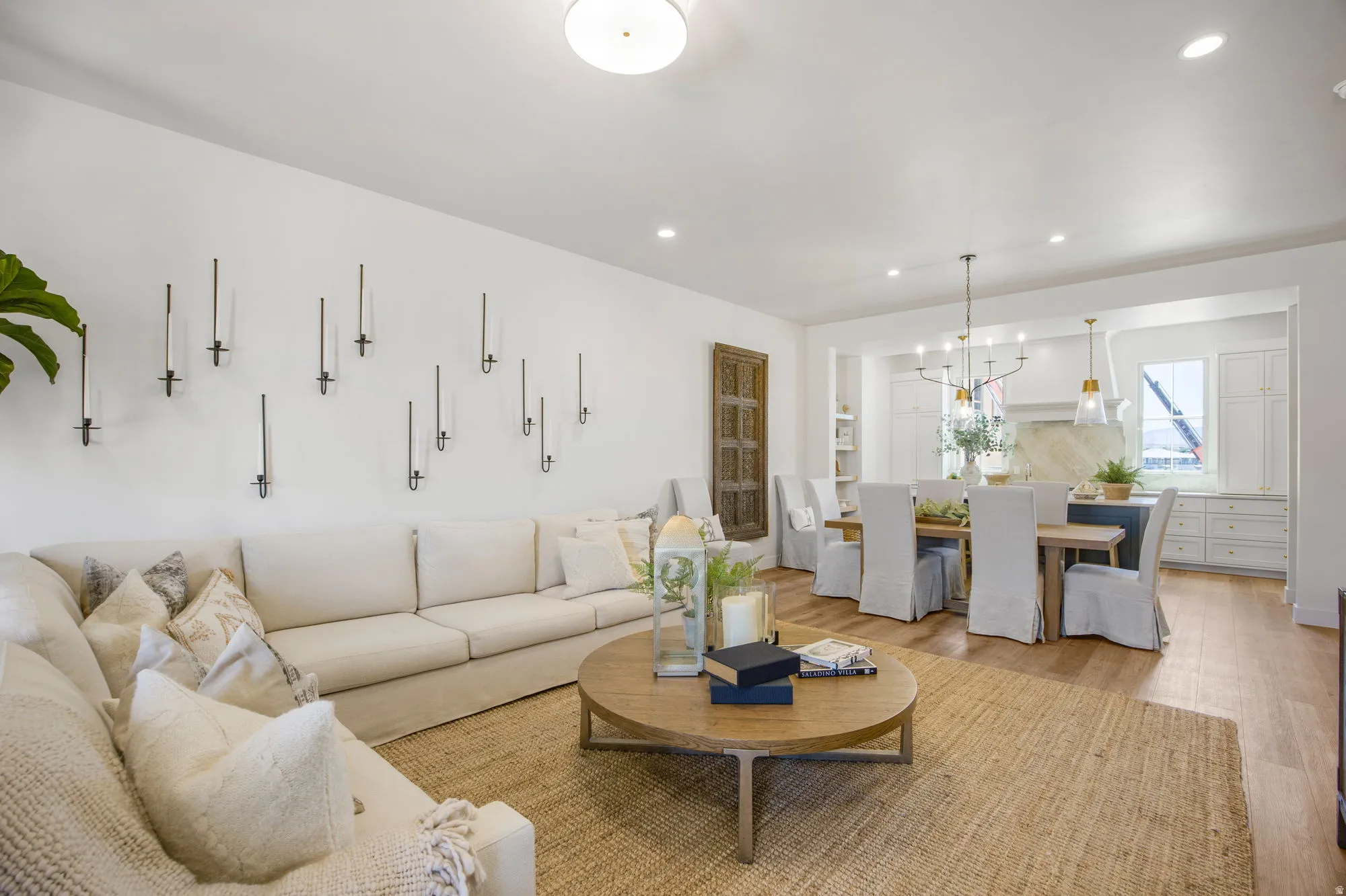 Open-concept living space featuring wood-finish flooring, recessed lighting, and a dining area with a chandelier