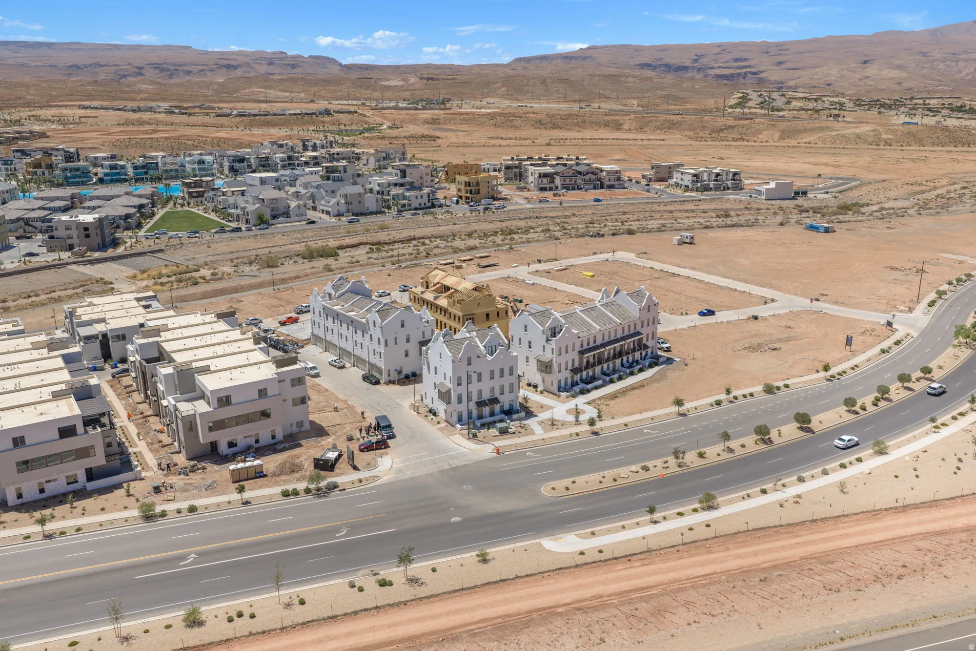 Expansive community development featuring modern and traditional architectural styles, multiple street networks, and surrounding desert landscape