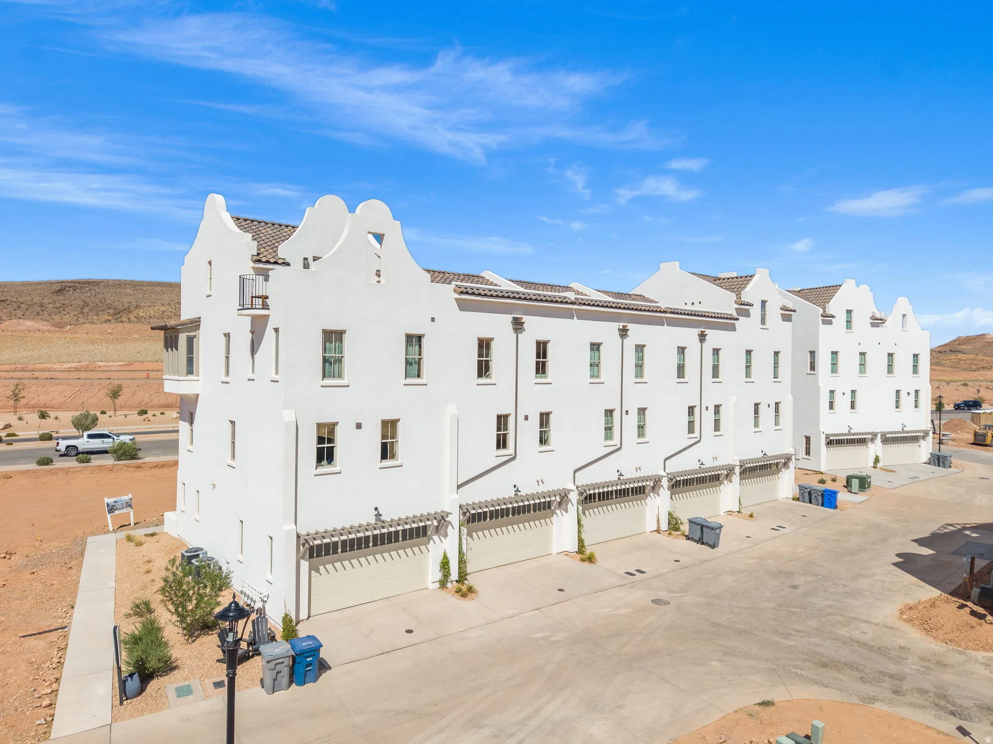 White stucco exterior with tiered gables, multi-pane windows, and a tile roof