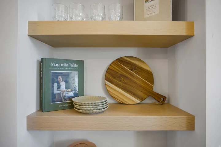 Built-in floating wooden shelves within an alcove