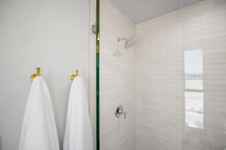 Shower with subway tile surround, chrome fixtures, and glass enclosure