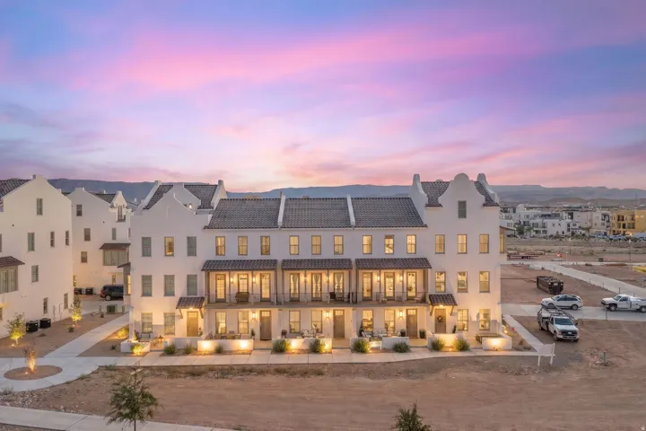 Row of townhomes featuring white stucco exteriors and dark tile roofs