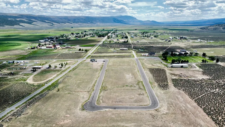 Expansive land offering a distinct road network, visible mountain backdrop, and scattered residential structures