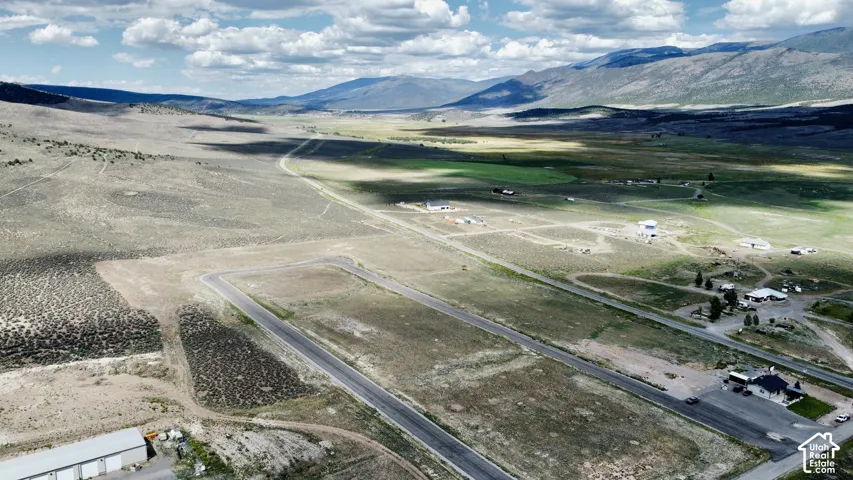 Expansive undeveloped land featuring paved roads and distant mountain ranges