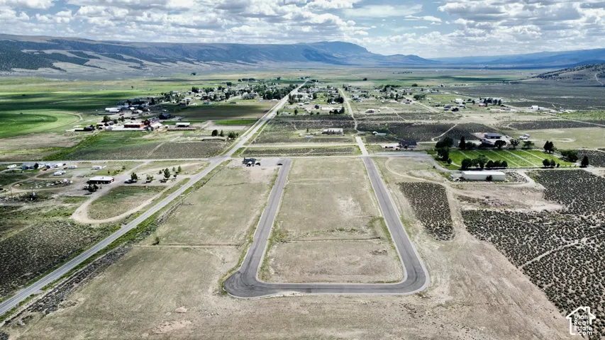Expansive land offering a distinct road network, visible mountain backdrop, and scattered residential structures