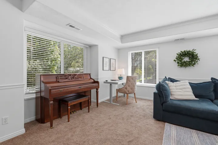 Tray ceiling, substantial window, carpeted flooring, and decorative wall molding