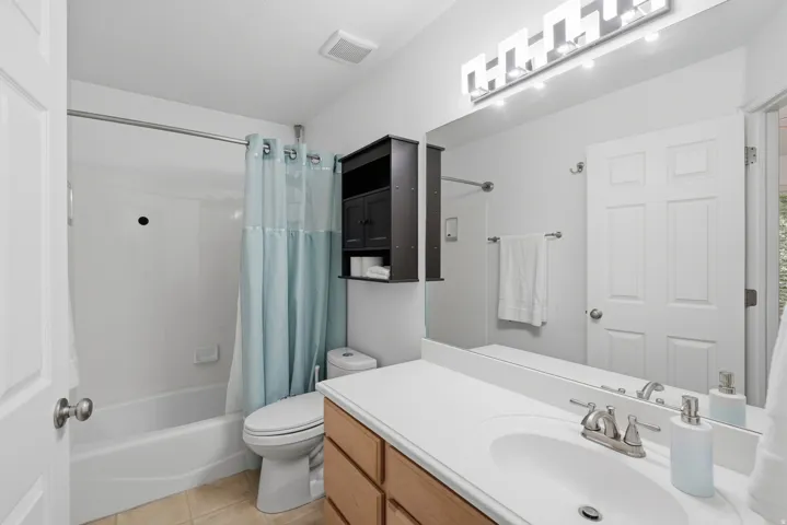 Single vanity with a white countertop and integrated sink, brushed nickel faucet, large wall mirror, and modern vanity lighting