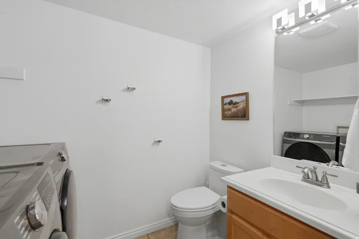 Vanity with a white countertop and integrated sink, chrome faucet, and wood-finish cabinetry