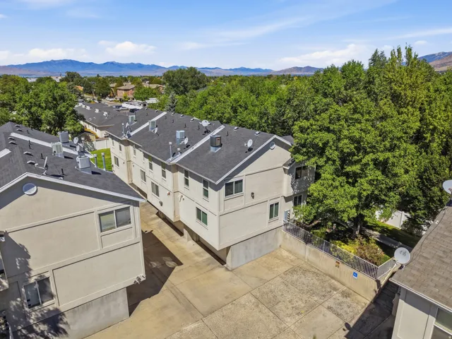 Multiple residential buildings with stucco exteriors and dark shingled roofs
