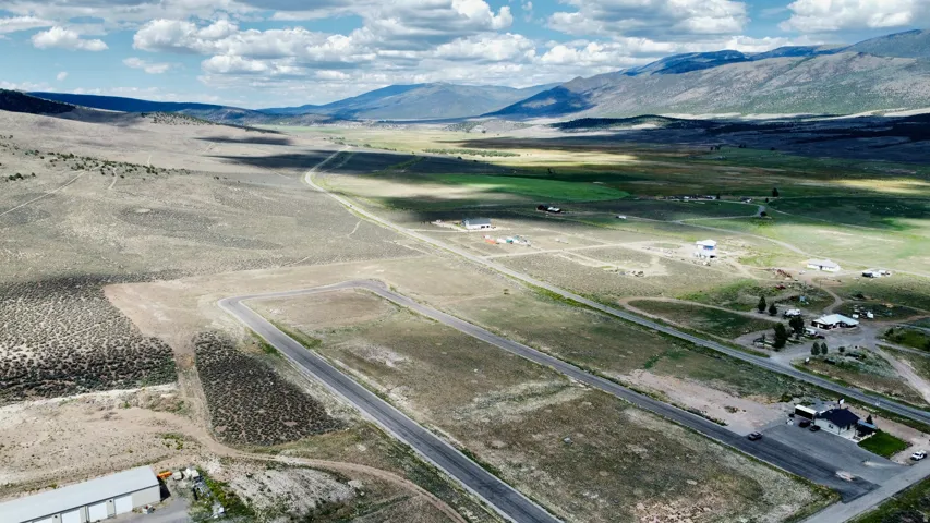 Expansive undeveloped land featuring paved roads and distant mountain ranges