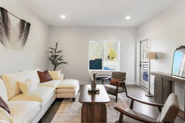 Recessed lighting, light-toned walls, wood-finish flooring, a large window, and a glass-paneled door