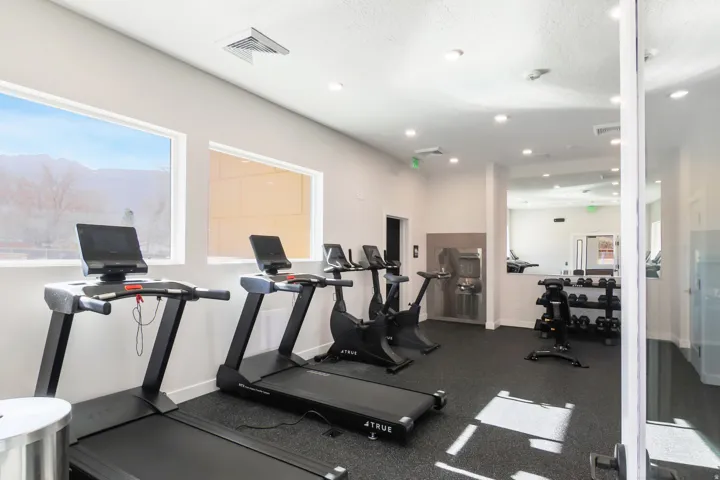 Fitness room featuring specialized rubber flooring, large windows, recessed lighting, and a water dispenser