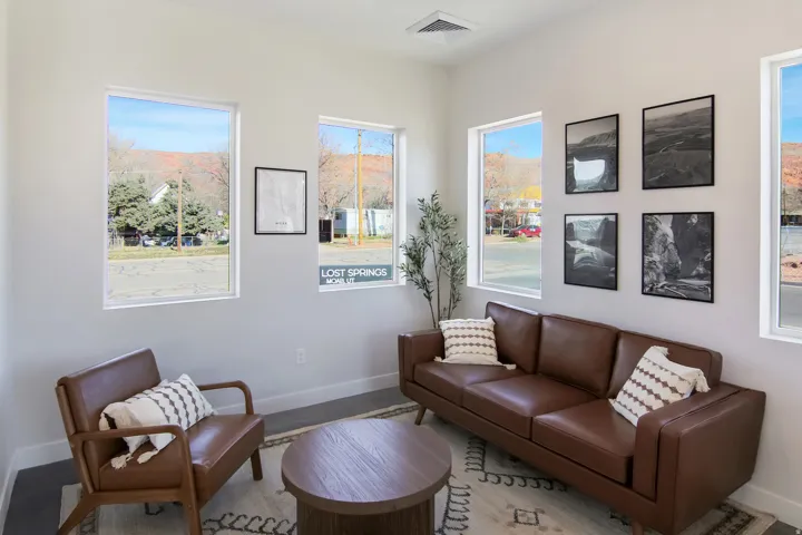 Recessed lighting, multiple windows, light-toned walls, and dark flooring