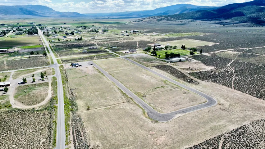 Expansive vacant land parcels featuring paved road access and distant mountain backdrop