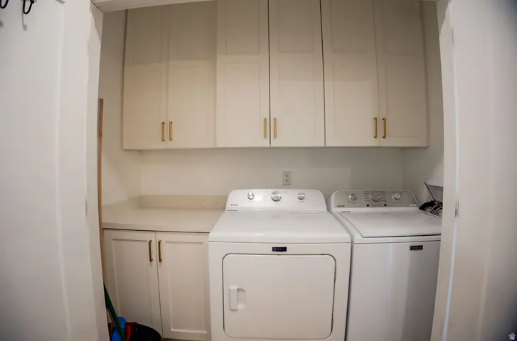 Built-in cabinetry with brass hardware, light-toned countertop, and white walls
