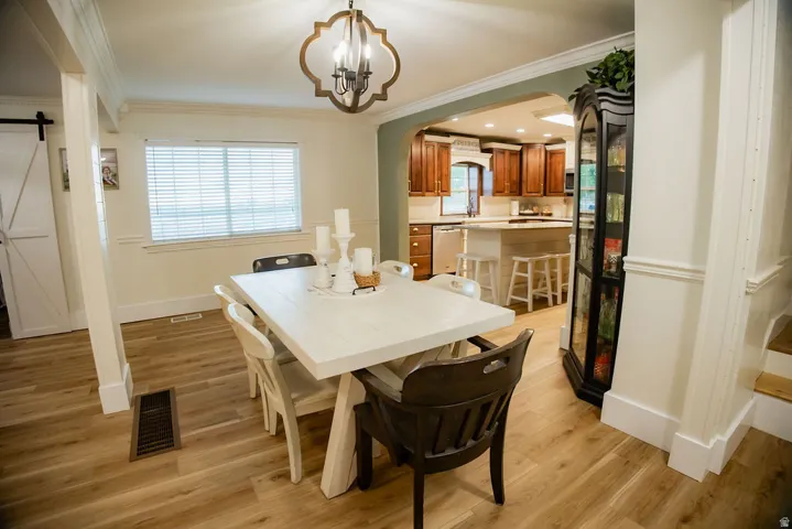 Wood-finish flooring throughout, white trim, and crown molding