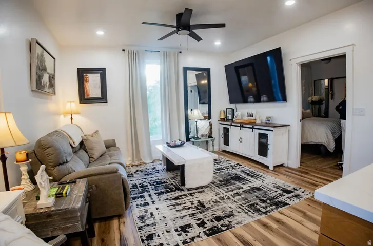 Recessed lighting, ceiling fan, wood-finish flooring, white trim, and a built-in media console