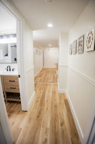 Wood-finish flooring throughout, white baseboards, and wainscoting detail