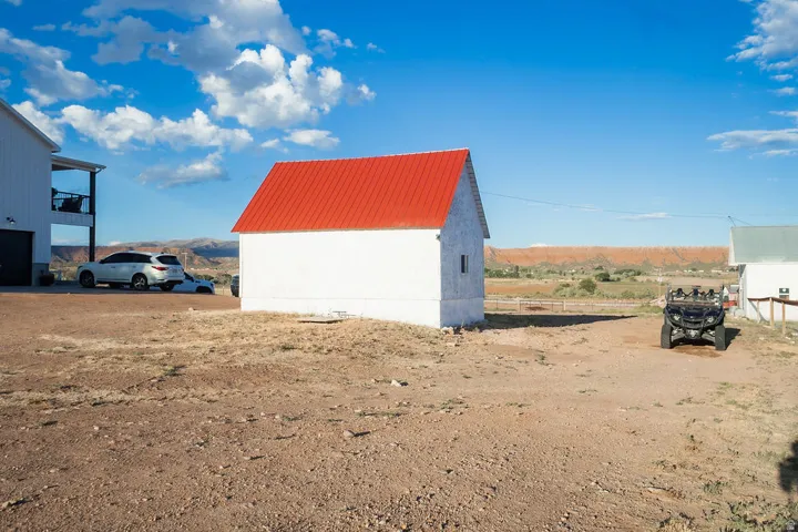 White exterior structure with a red metal roof