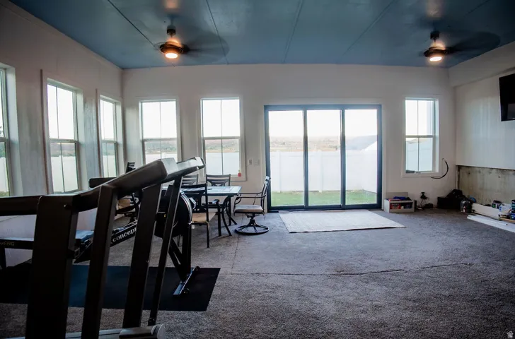 Recessed lighting, dual ceiling fans, multiple windows, and a sliding glass door