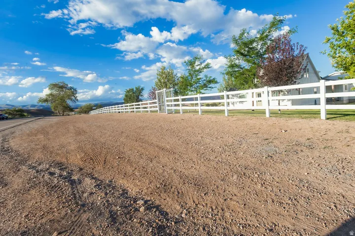 Expansive gravel area with a white post-and-rail fence