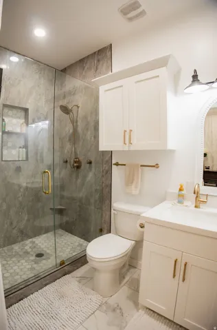 Walk-in shower with full-height tile surround and glass enclosure