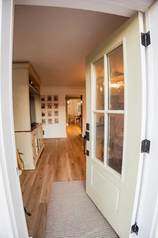 Light-colored entry door with decorative glass panels and dark hardware