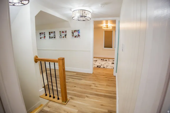 Wood-finish flooring throughout, with a wood handrail and black metal balusters