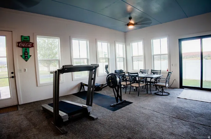 Spacious room featuring multiple large windows, a full-light French door, and a sliding glass door