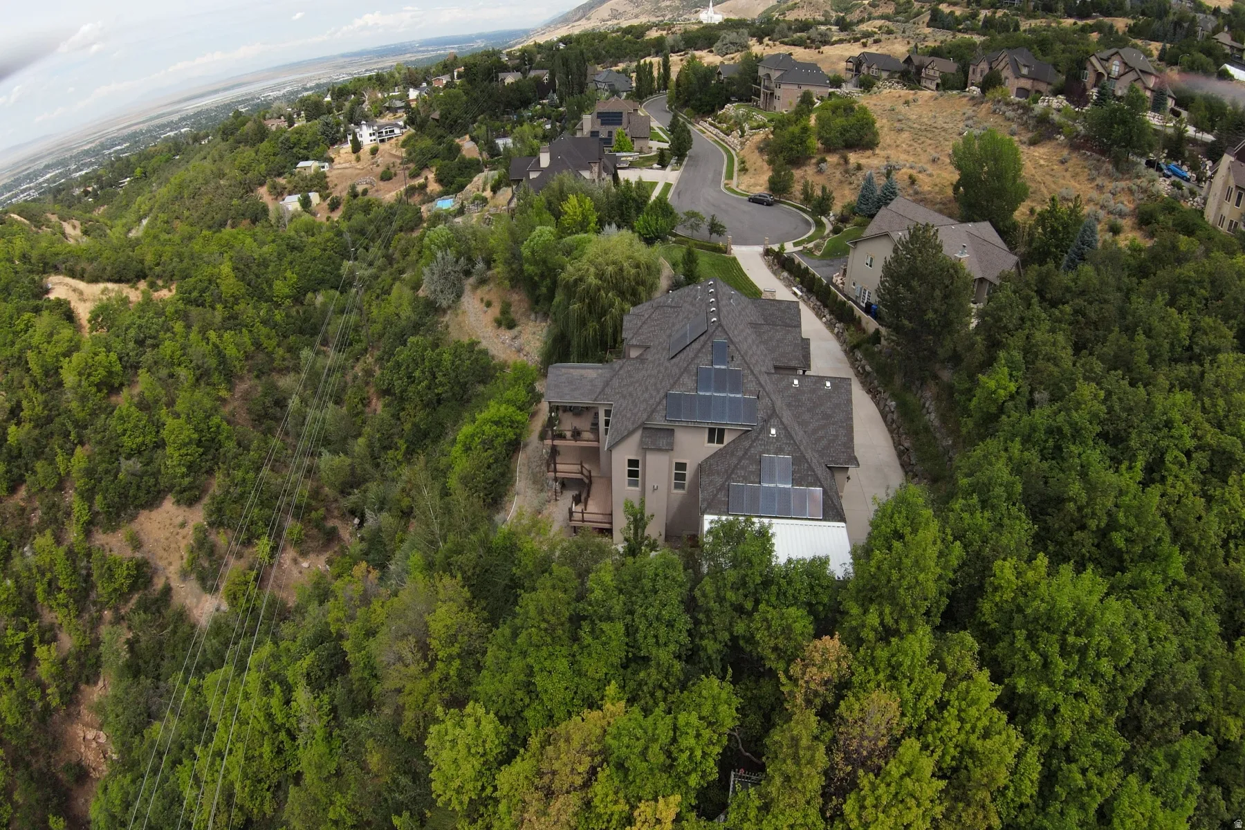 Striking architectural residence nestled on a heavily wooded lot with mature evergreen and deciduous trees