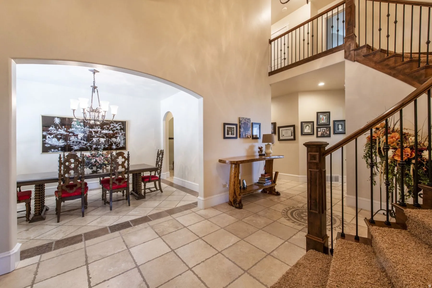 Two-story foyer with curved staircase, wrought iron balusters, and wood-finish handrails