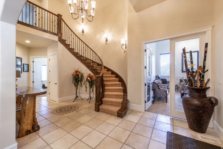 Grand foyer featuring a curved staircase with wood treads and wrought iron balusters