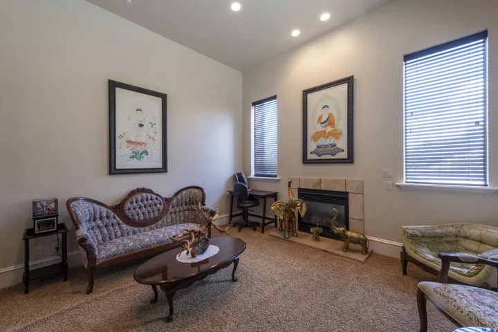 Recessed lighting illuminates a neutral wall color, complemented by two windows with blinds