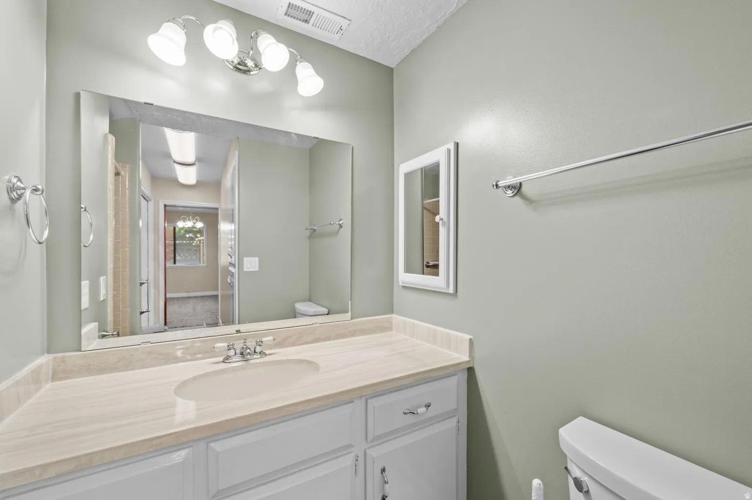Vanity with integrated sink, stone-finish countertop, and white cabinetry
