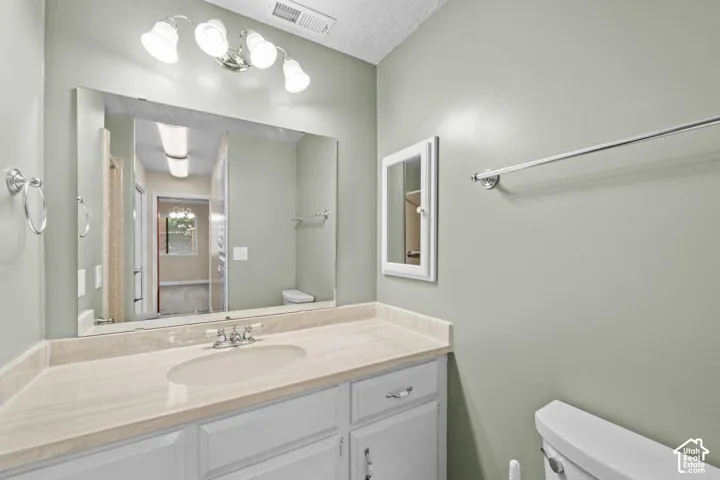 Vanity with integrated sink, stone-finish countertop, and white cabinetry