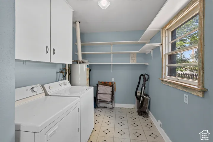 Laundry area featuring white cabinetry, tiered shelving, and a patterned floor