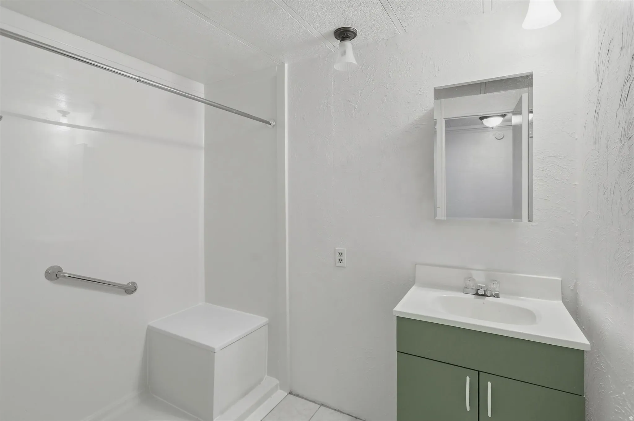 Step-in shower with grab bar and integrated seating