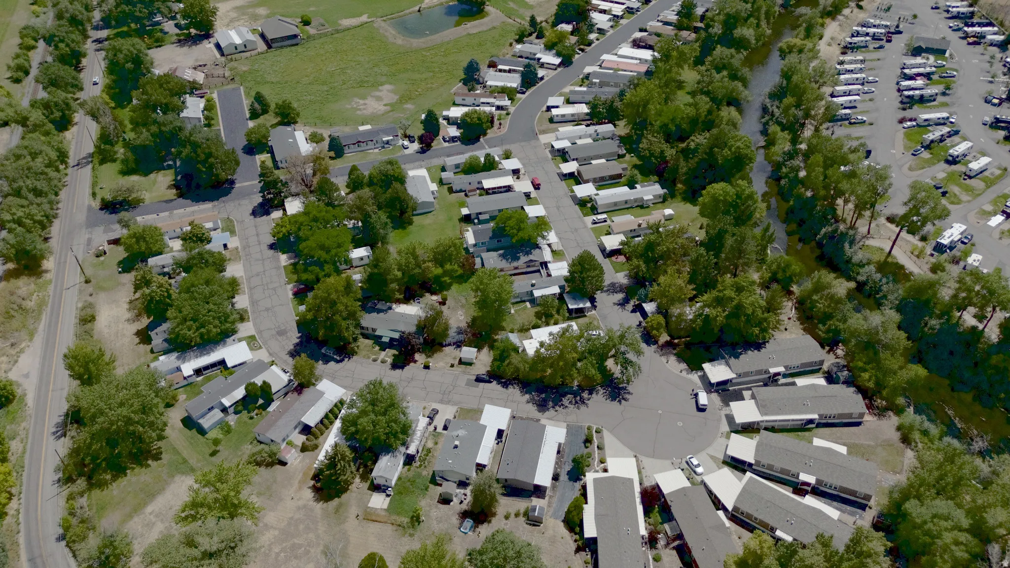 Aerial perspective of HOA with abundant mature trees and paved roads