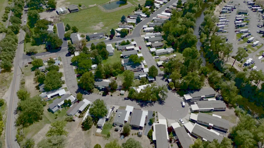 Aerial perspective of HOA with abundant mature trees and paved roads