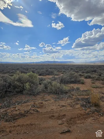 Expansive open land featuring arid vegetation and distant natural formations