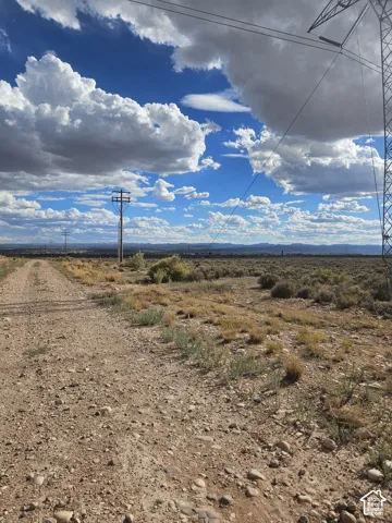 Expansive undeveloped land featuring a gravel path and scattered desert vegetation